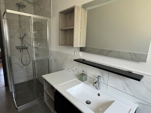 Bañera con ducha, toallas, papel higiénico