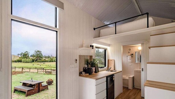 Cocina compacta con vista a un espacio exterior cubierto de césped.