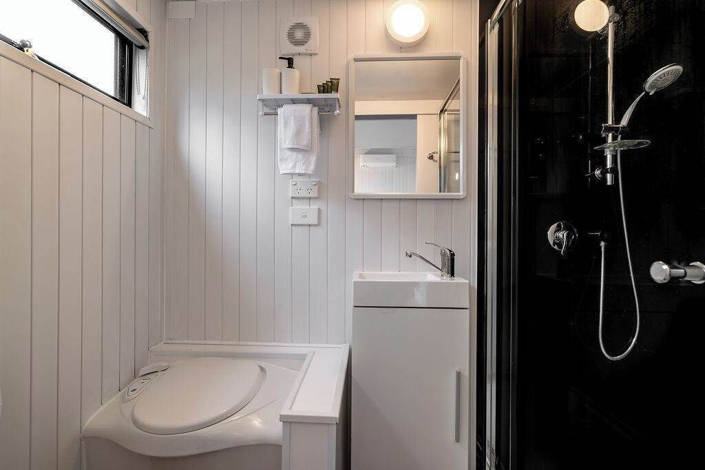 A modern bathroom with a toilet, sink, and shower.