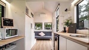 Una cocina moderna con microondas, lavamanos y un cartel de bienvenida.