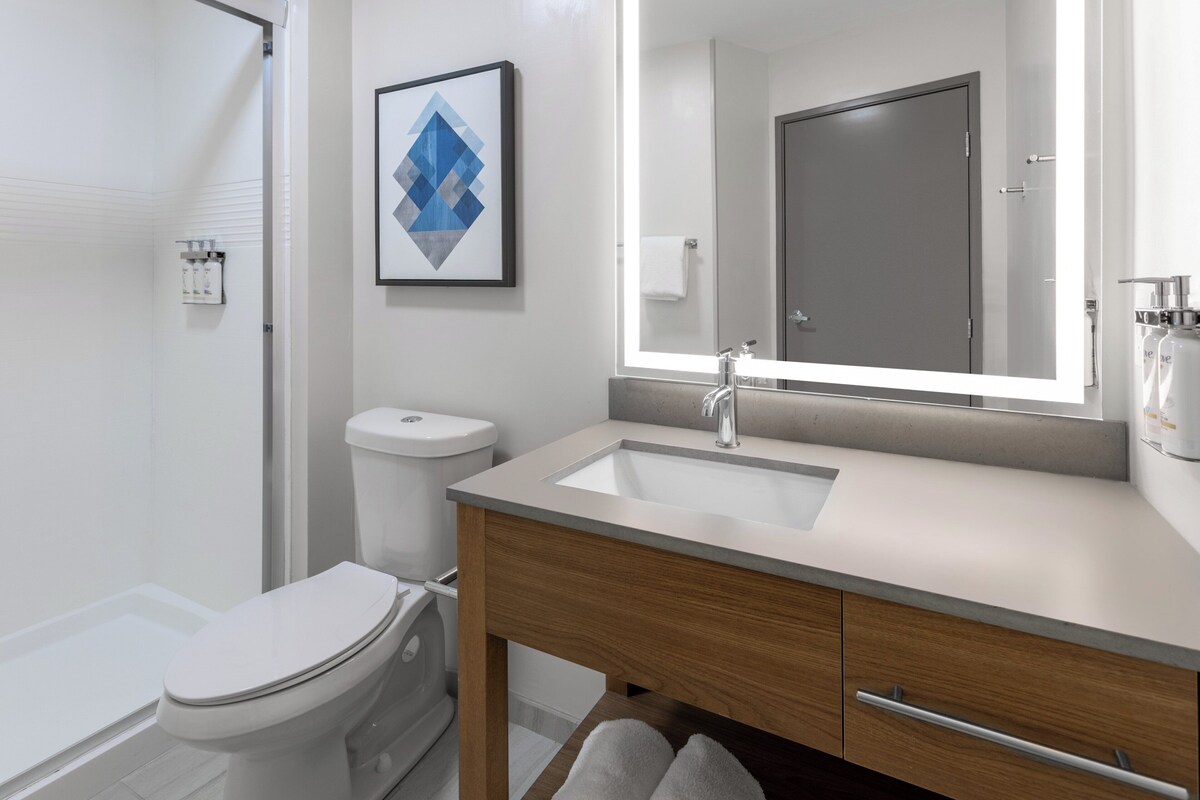 Une salle de bain moderne avec des toilettes, un lavabo et un miroir.