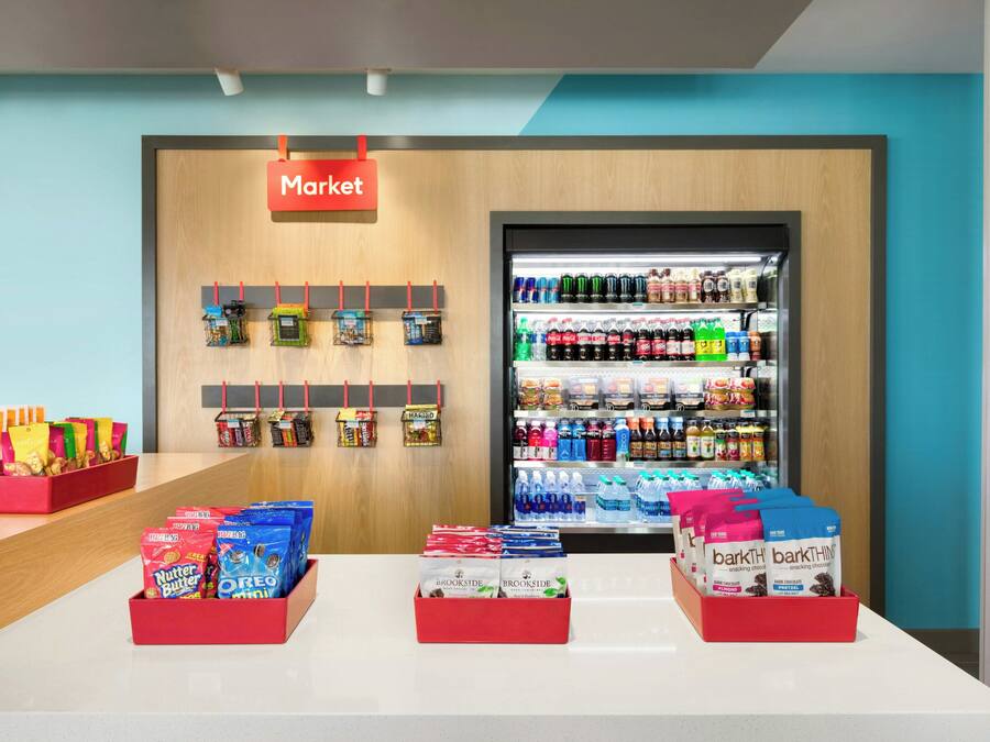 A snack display area with various packaged snacks and a refrigerated section with beverages.