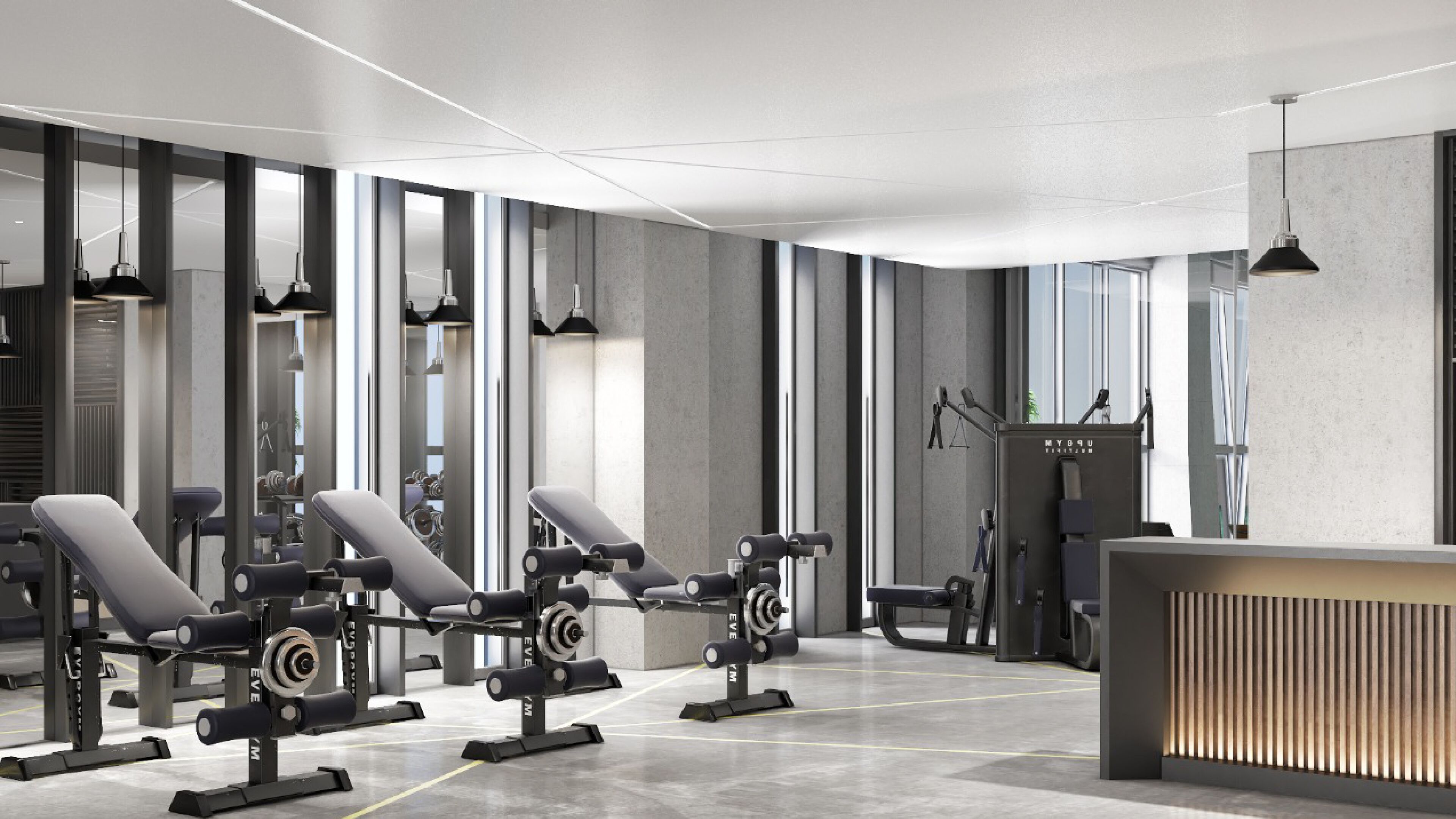A modern gym with weightlifting equipment, benches, and a reception desk.