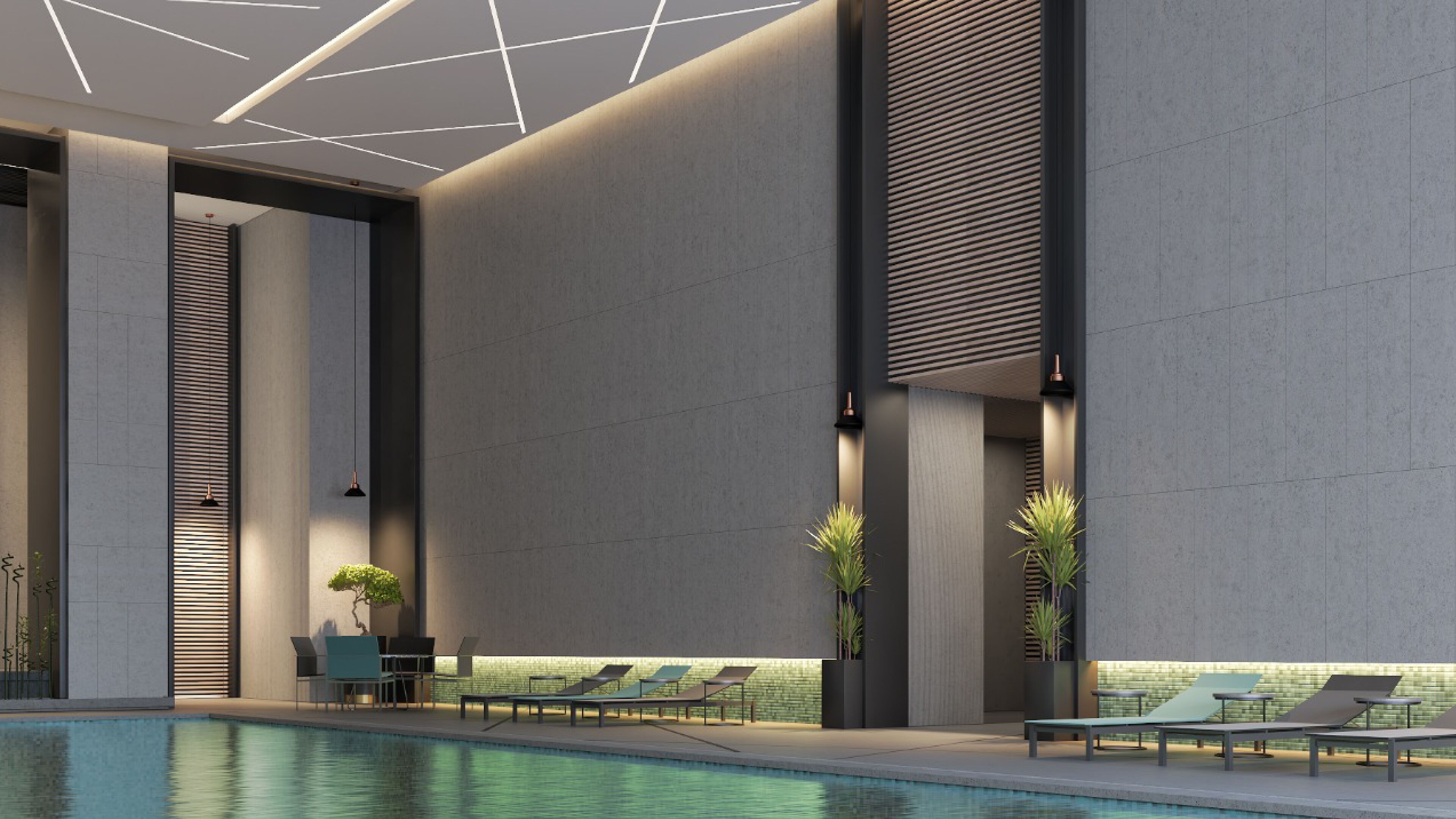 Un espace piscine intérieur moderne, doté de chaises longues et d’une table, entouré de hauts murs et caractérisé par un design minimaliste.
