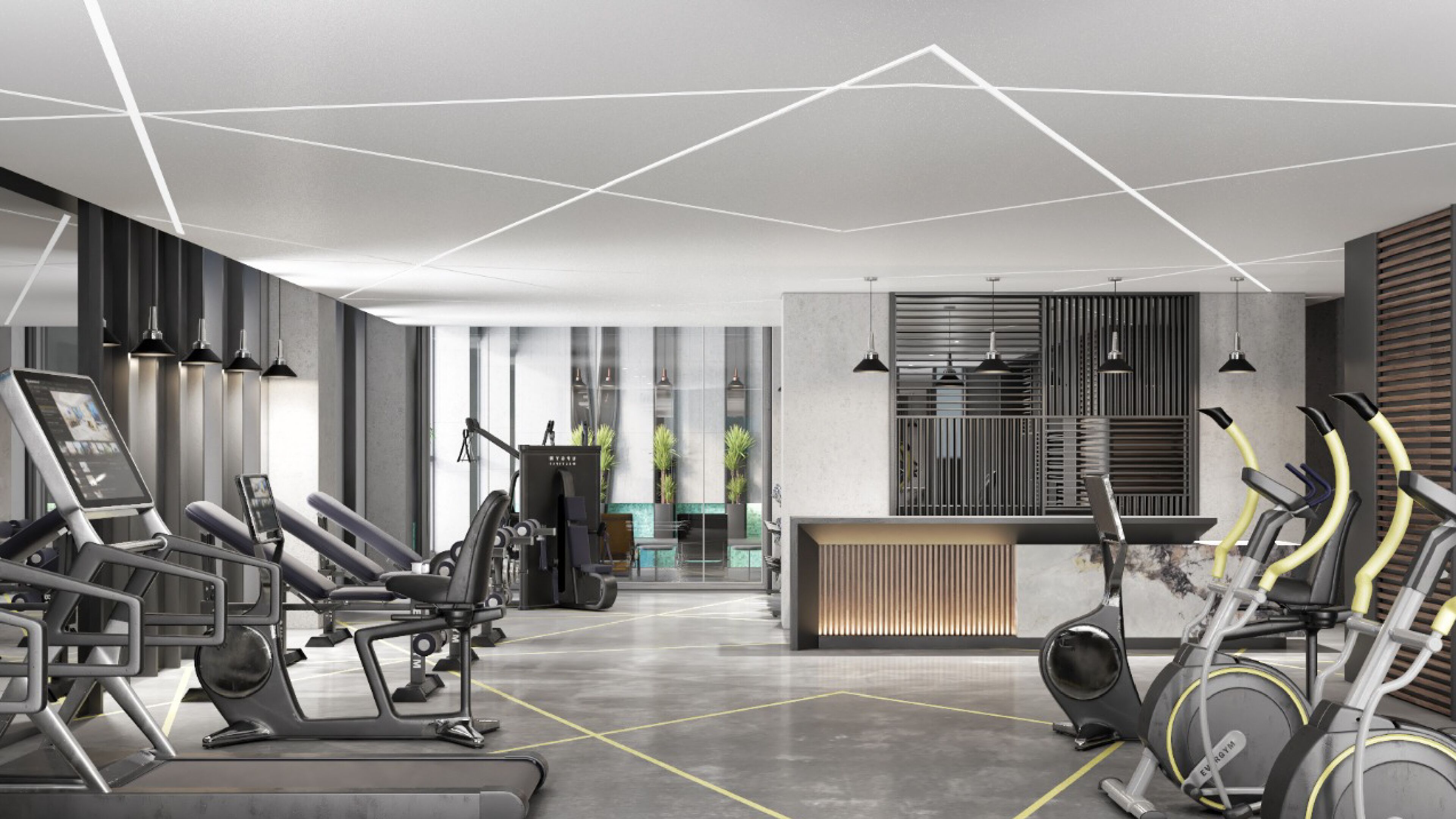 Ett modernt gym med olika typer av träningsutrustning, en reception och utsikt över omgivningarna.
