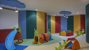Ein Spielbereich für Kinder mit Rutsche, Klettergerüsten und einer Schaukel.