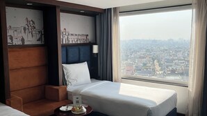 A hotel room with two beds, a city view, a large window with curtains, and artwork on the wall. - Holiday Inn Express & Suites Jaipur Gopalpura by IHG (Jaipur)