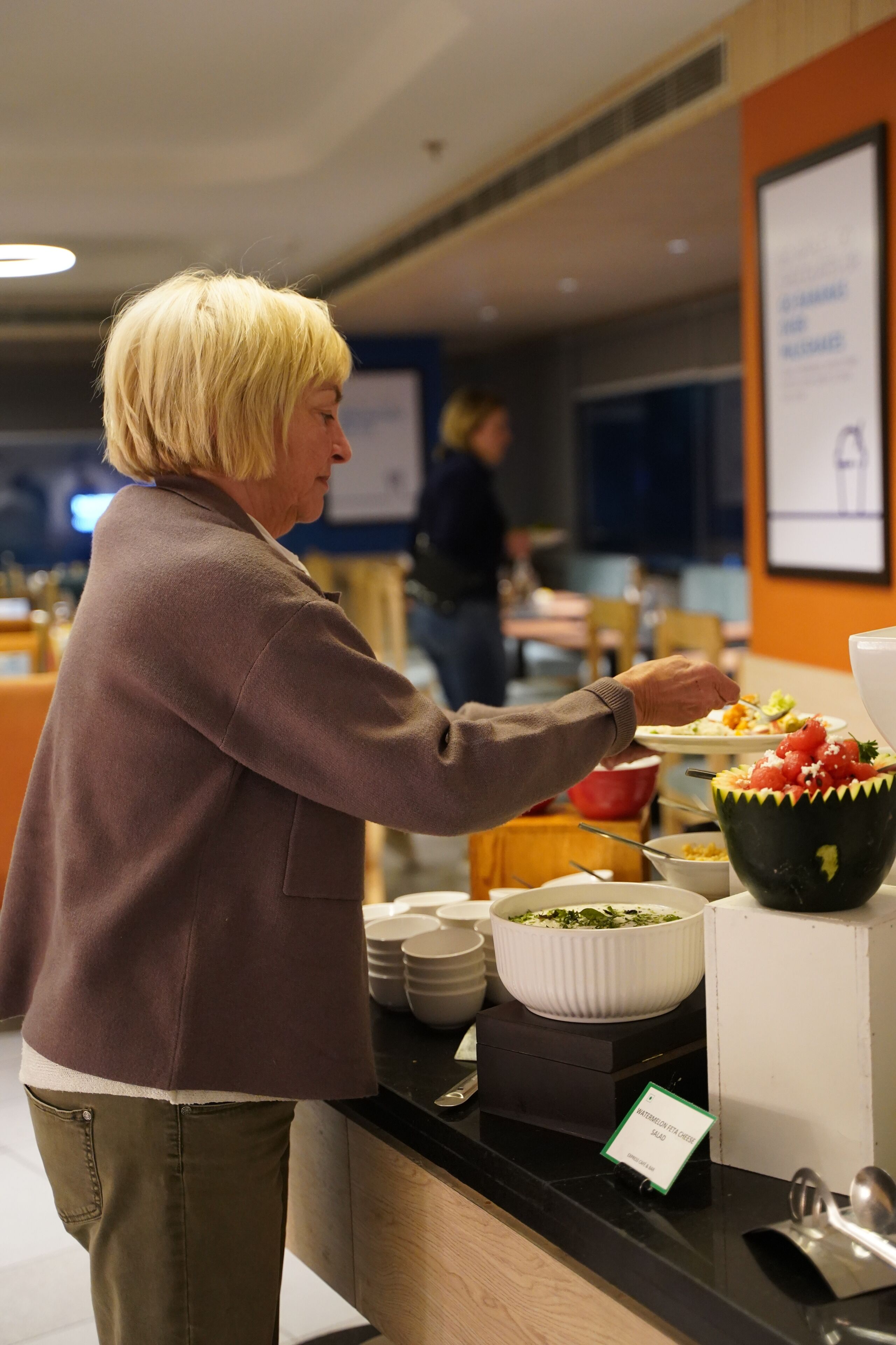 A buffet area with various food items and a sign indicating a vegetarian option.