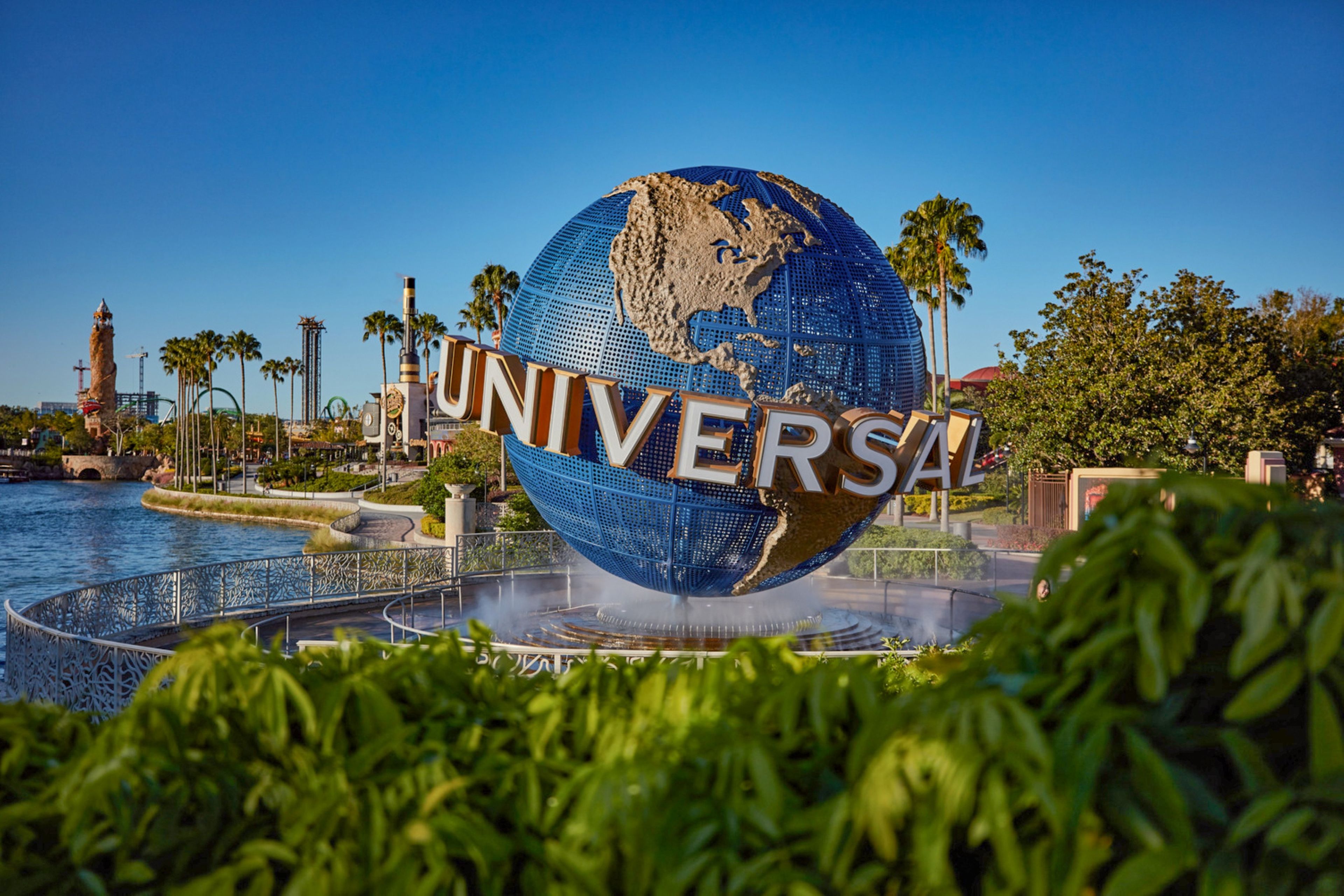 Un grand globe sur lequel est inscrit le mot « UNIVERSAL », entouré d’eau et de végétation.