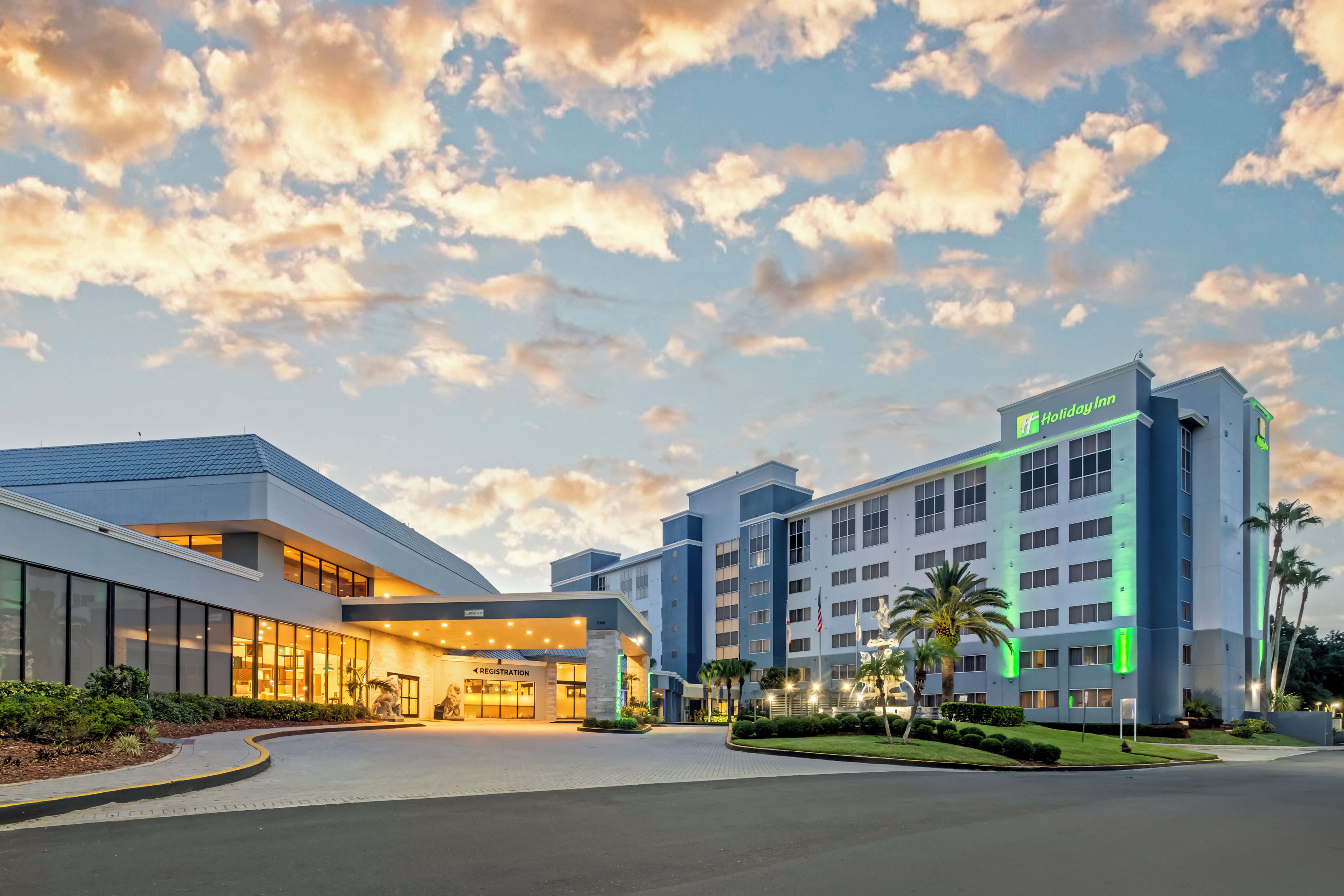 A Holiday Inn hotel with a modern design, featuring a registration area and a well-lit entrance.