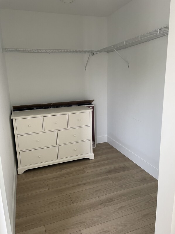 A room with a white dresser, wooden flooring, and a metal shelf on the ceiling. - SNL New condominium one block from West Bay. Great location. (Traverse City)