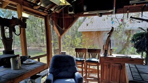 Une cabane en bois rustique comprenant un coin repas, des chaises et une table.