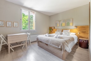 A bedroom with a wooden bed, a desk, and a radiator.