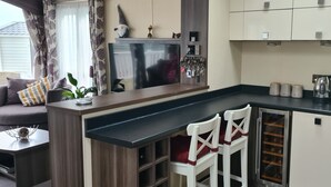 Eine kompakte Küche mit integriertem Kühlschrank, einer Kaffeemaschine und einem Weinkühler.