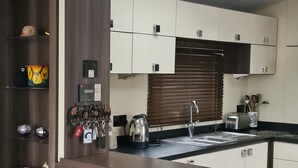 Eine moderne Küche mit integriertem Kamin, einem Oberlicht und einem Holzregal mit Dekoration.