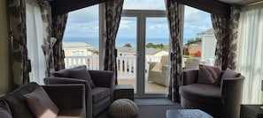 A balcony with two sofas and a table, overlooking a residential area and the sea. - Spectacular Views of Swanage Bay and Downs (Swanage)