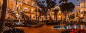 A hotel with multiple floors, a swimming pool, and palm trees. - Key West, FL - Ocean Front - Coconut Beach Resort (Key West)
