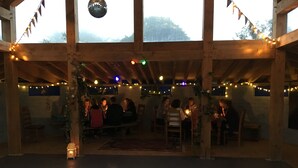 A rustic wooden interior with a high ceiling, string lights, and a disco ball. - Eco Glamping immersed in nature, ideal for family holidays andromantic getaways! (Whitegate)