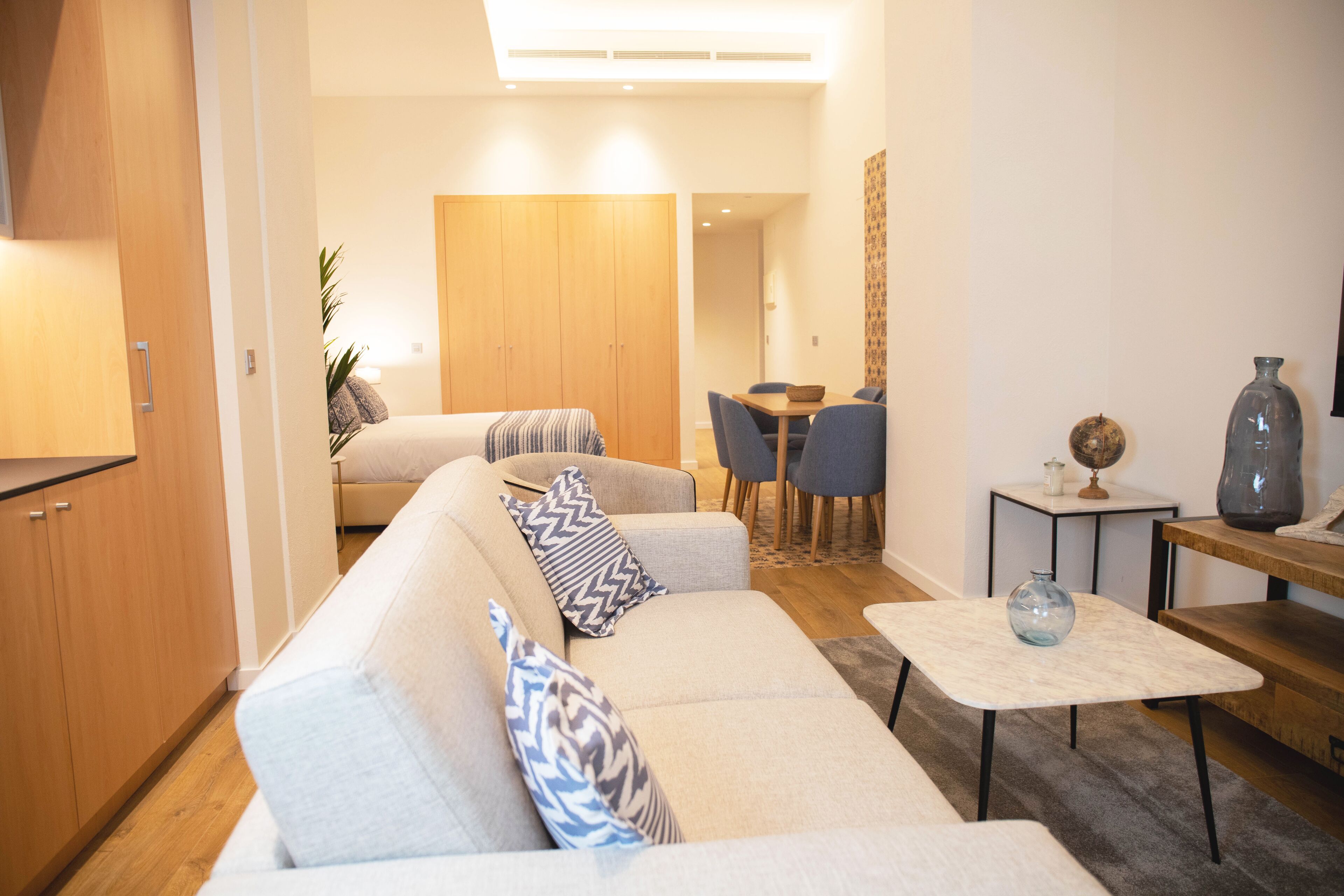 Ein modernes Wohnzimmer mit Sofa, Couchtisch und Essbereich.