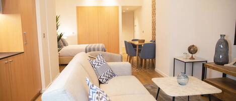 A modern living room with a sofa, coffee table, and dining area.