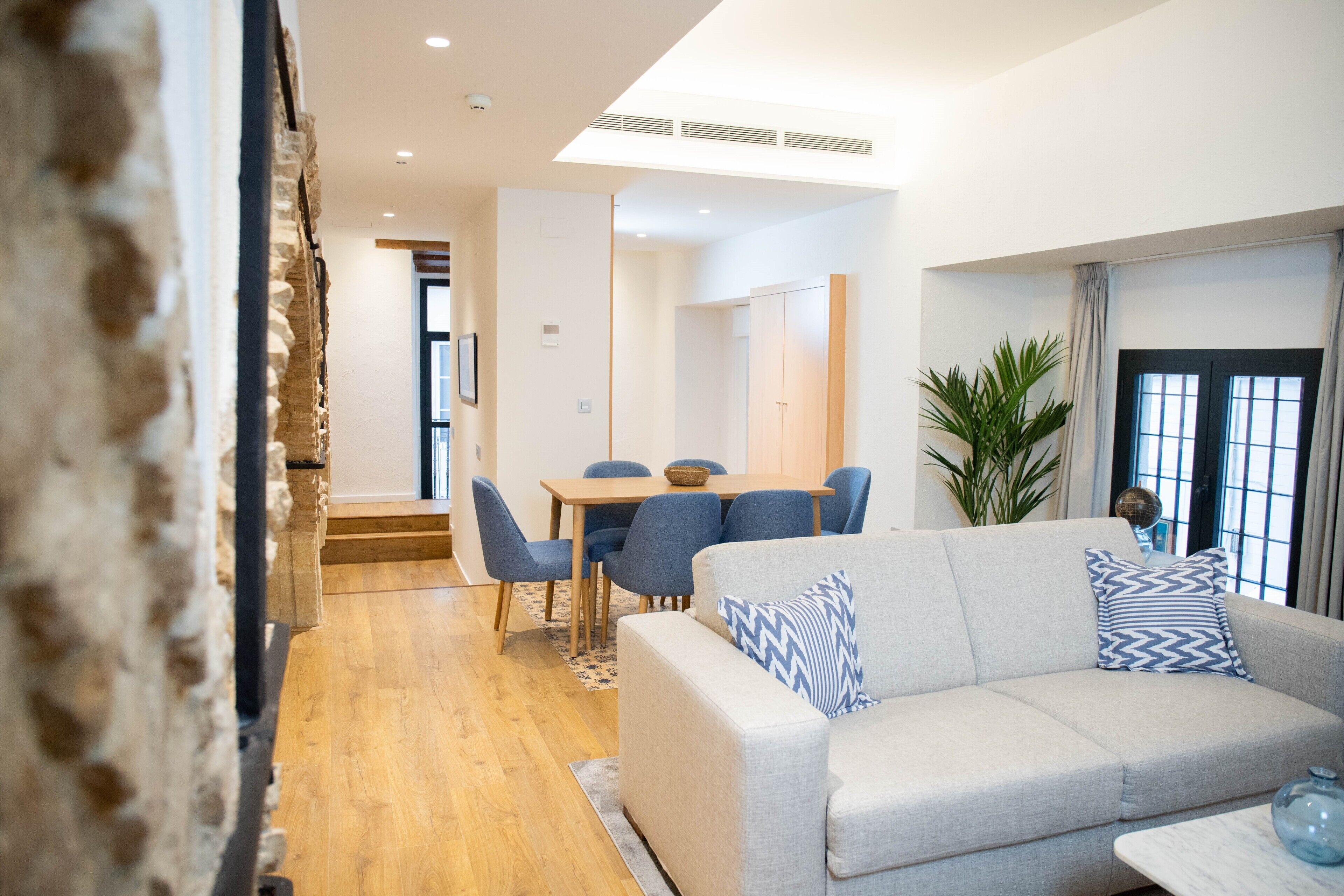 Un salon moderne comprenant un canapé, une table basse et un coin repas avec une table et des chaises.