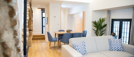 Un salon moderne comprenant un canapé, une table basse et un coin repas avec une table et des chaises.