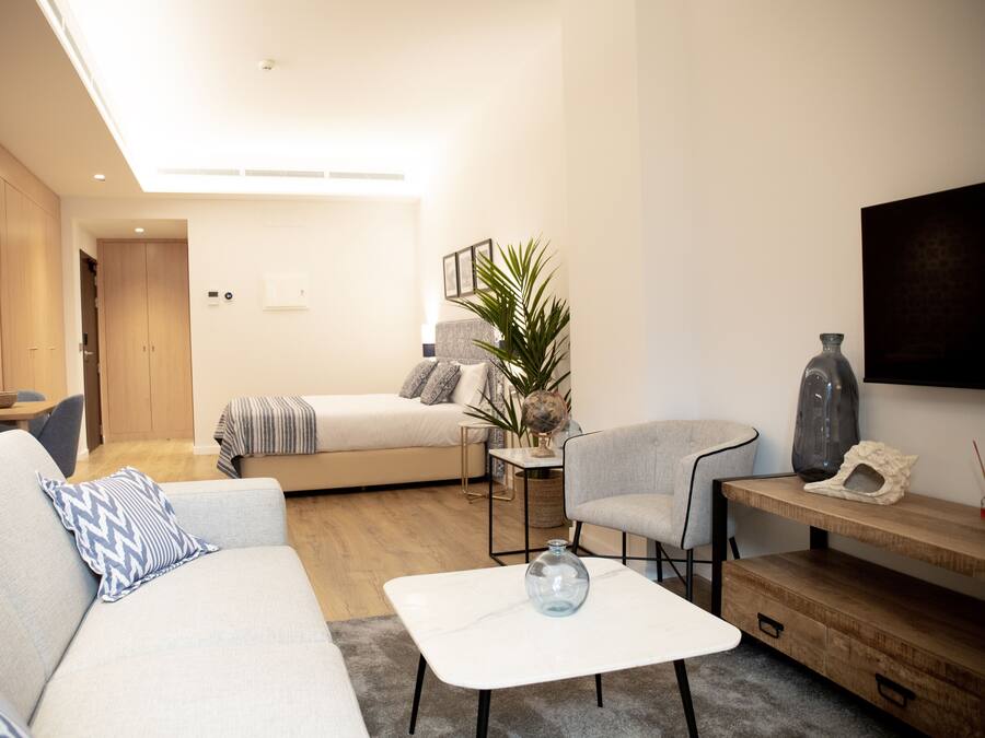 Un salon moderne avec un canapé, une table basse et un téléviseur fixé au mur.