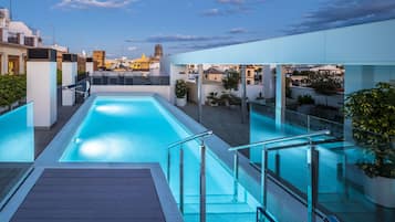 Una piscina al aire libre de temporada, sombrillas