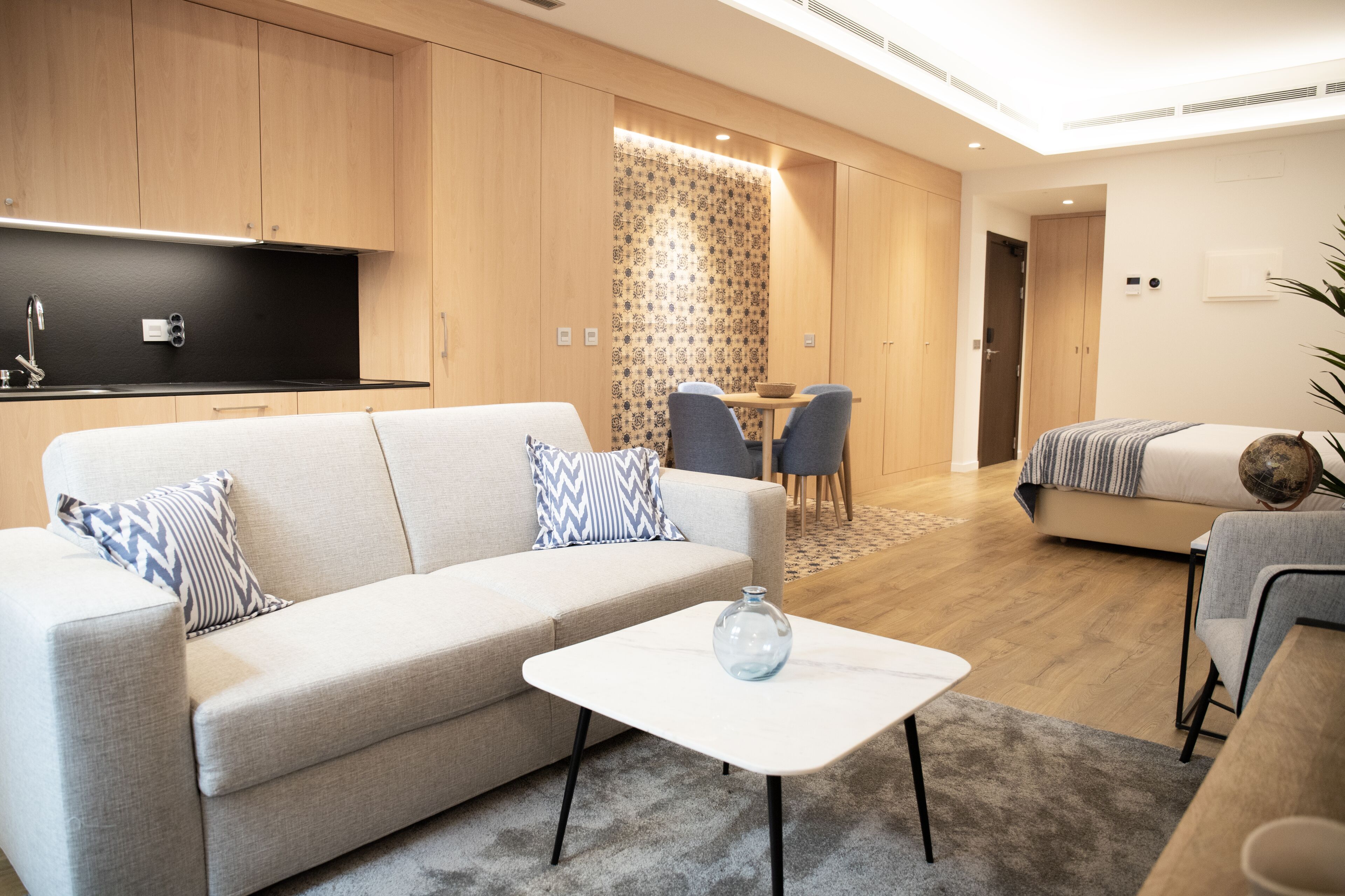 Ein modernes Wohnzimmer mit einer Couch, einem Couchtisch und einem Essbereich mit Stühlen.