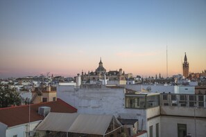 A cityscape with a prominent cathedral and a clock tower, surrounded by residential buildings. - nQn Aparts & Suites Sevilla (Seville)