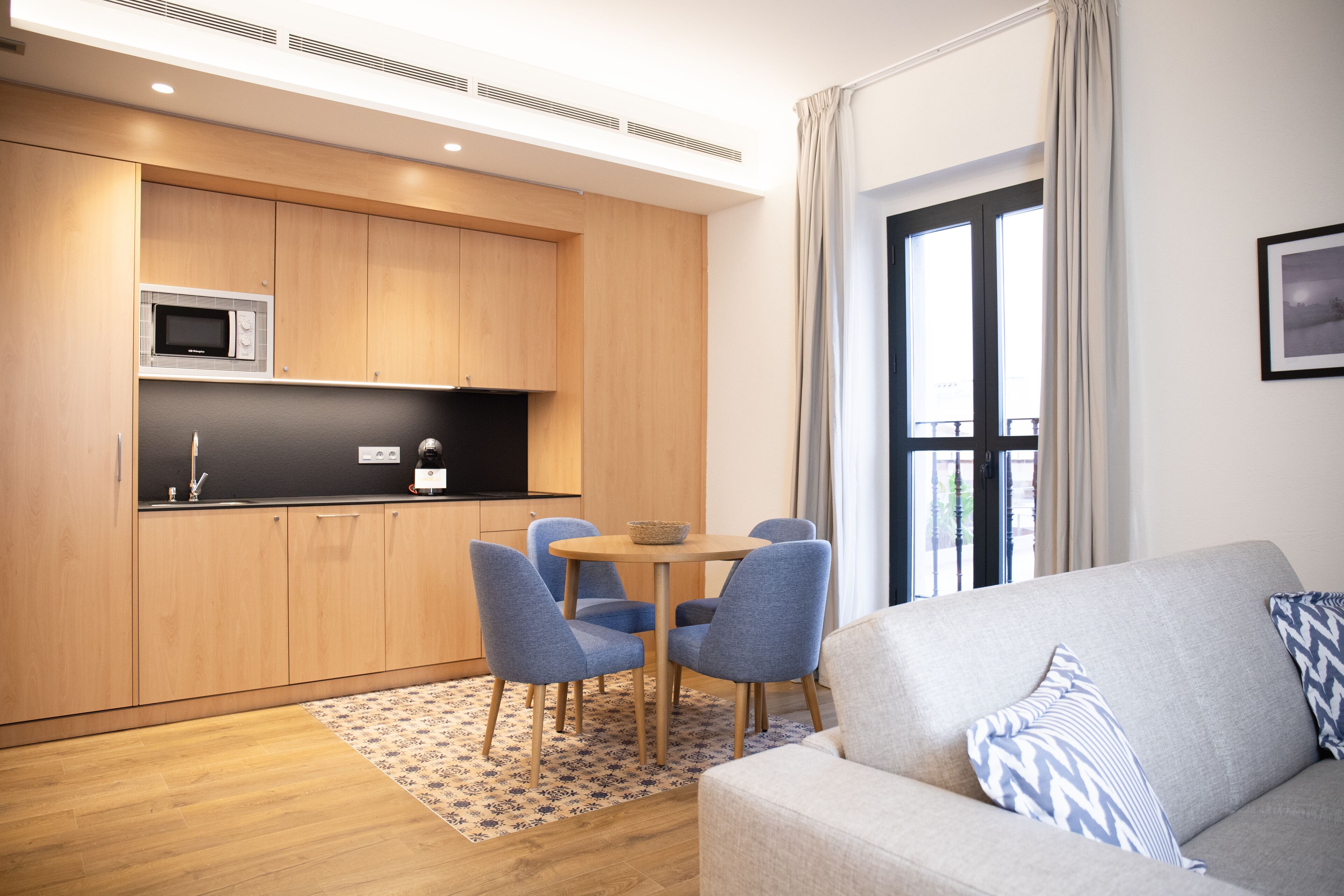 A modern apartment with a kitchen, dining area, and living room.