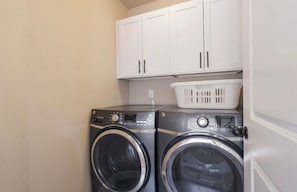 A laundry area with two washing machines and a white cabinet above them. - Patio w/ fire pit home ✶ 10min to DT → Has it all! (Portland)