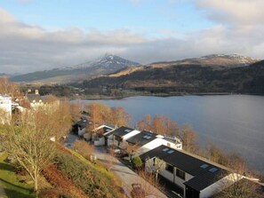 Une vue sur le lac, avec des chalets modernes et une montagne en arrière-plan.