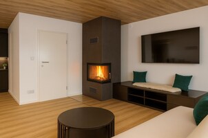 Apartamento panorâmico | Área de estar | Smart TV 170 cm com canais via satélite, TV, lareira