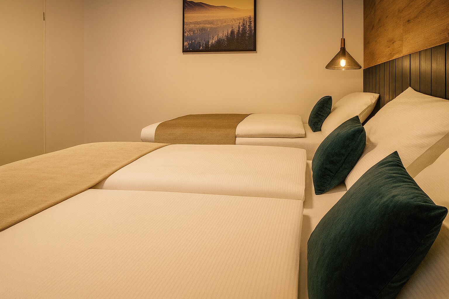 A room with three beds arranged in a row, each with a pillow and a blanket.