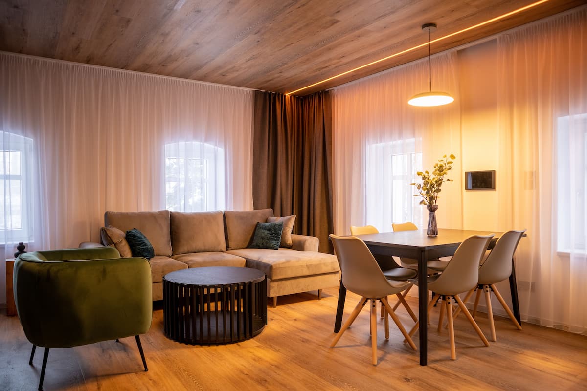 Un salon moderne avec un canapé, une table basse ronde et une table à manger avec des chaises.