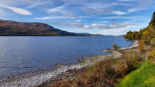 A lake with a rocky shoreline and a path leading to a grassy area. - Loch Rannoch Highland Club, Lochside Lodge 7 (Kinloch Rannoch)