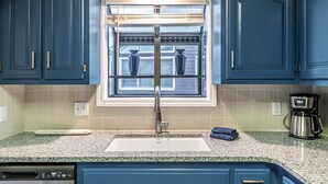 A kitchen with blue cabinets, a stainless steel dishwasher, and a coffee maker. - Sleep 8 in this guest fave! All new, fresh & fun!walk to lake and marina. (Holiday Island)