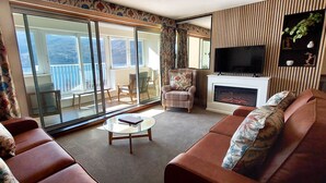 A living room with a sofa set, a coffee table, a fireplace, and a television. - Loch Rannoch Highland Club, Otter Lodge 3 (Kinloch Rannoch)