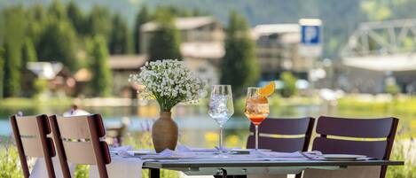 A table set for two with a view of a lake and mountains in the background.