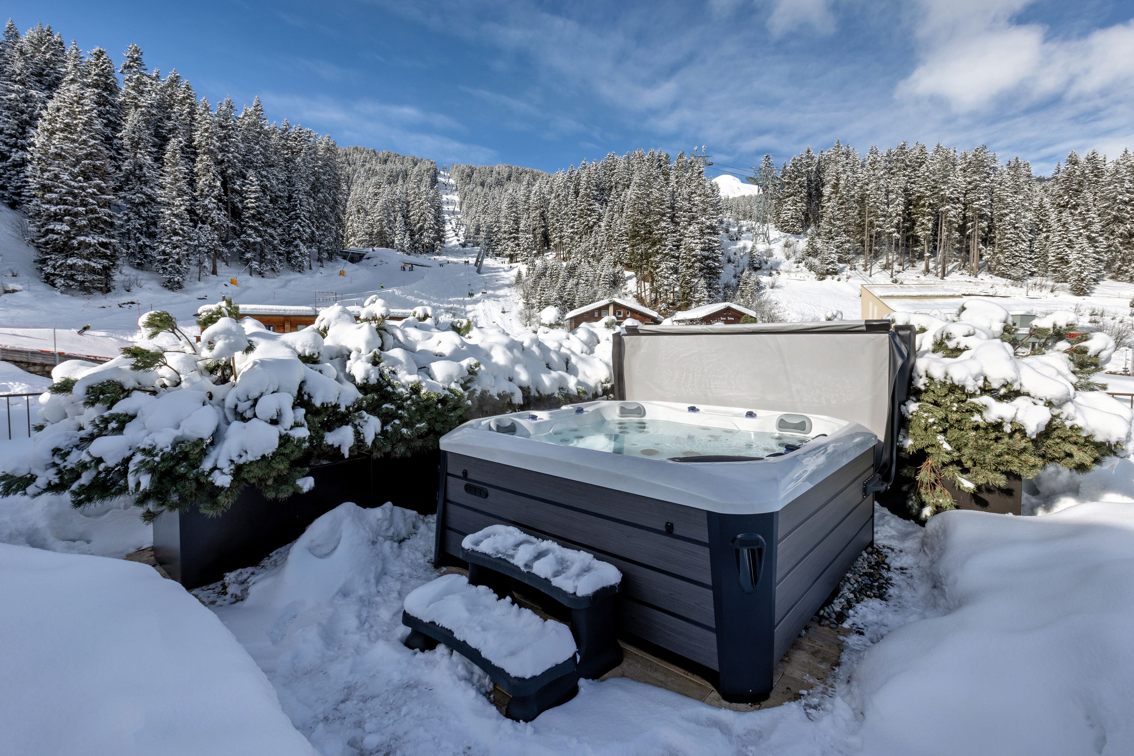 A hot tub in a snowy outdoor setting with a mountainous backdrop.
