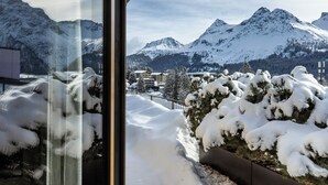 A snowy mountain landscape with a view of a building and a snow-covered garden. - Postresidenz am See (Arosa)