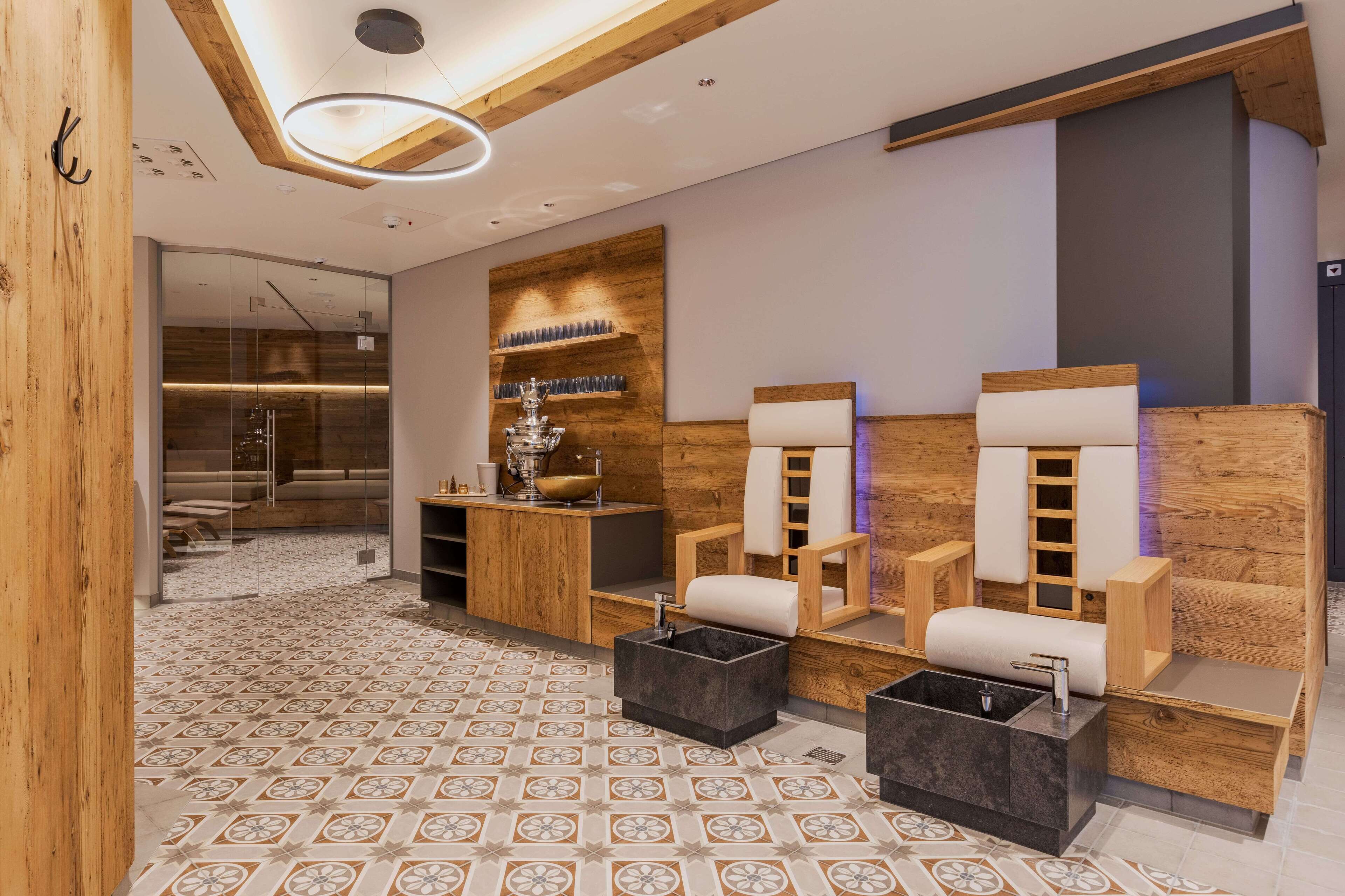 A modern spa area with wooden accents, a large mirror, and a seating area with a massage table.