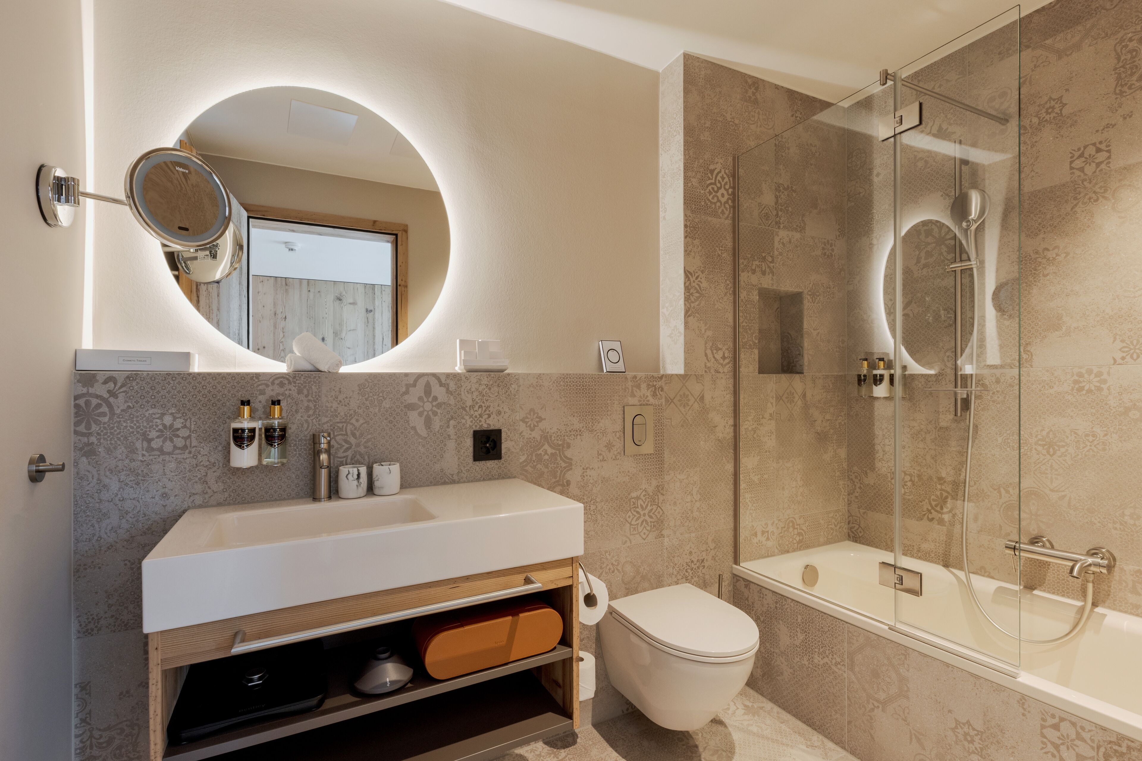 Un baño moderno con tocador, inodoro y ducha con cerramiento de vidrio.