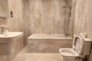 A bathroom with a bathtub, a sink, and a toilet. - Loch Rannoch Highland Club, Highland Lodge 44 (Kinloch Rannoch)