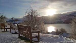A bench overlooking a lake with mountains in the background. - Loch Rannoch Highland Club, Red Squirrel 4 (Kinloch Rannoch)