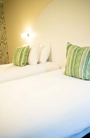 A hotel room with a bed, pillows, and a wall-mounted light fixture. - Loch Rannoch Highland Club, Red Squirrel 1 Lodge (Kinloch Rannoch)