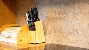 A kitchen with a wooden countertop, a built-in stove, and a knife block. - Loch Rannoch Highland Club, Red Squirrel Lodge 8 (Kinloch Rannoch)
