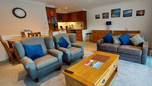Een woonkamer met twee banken, een salontafel en een eethoek met stoelen en een tafel.