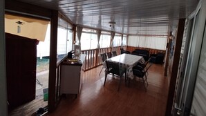 A covered outdoor dining area with a table and chairs, a small kitchenette, and a view of the outside. - Mobile home with air conditioning near the ocean and plenty of places to explore (La Tremblade)